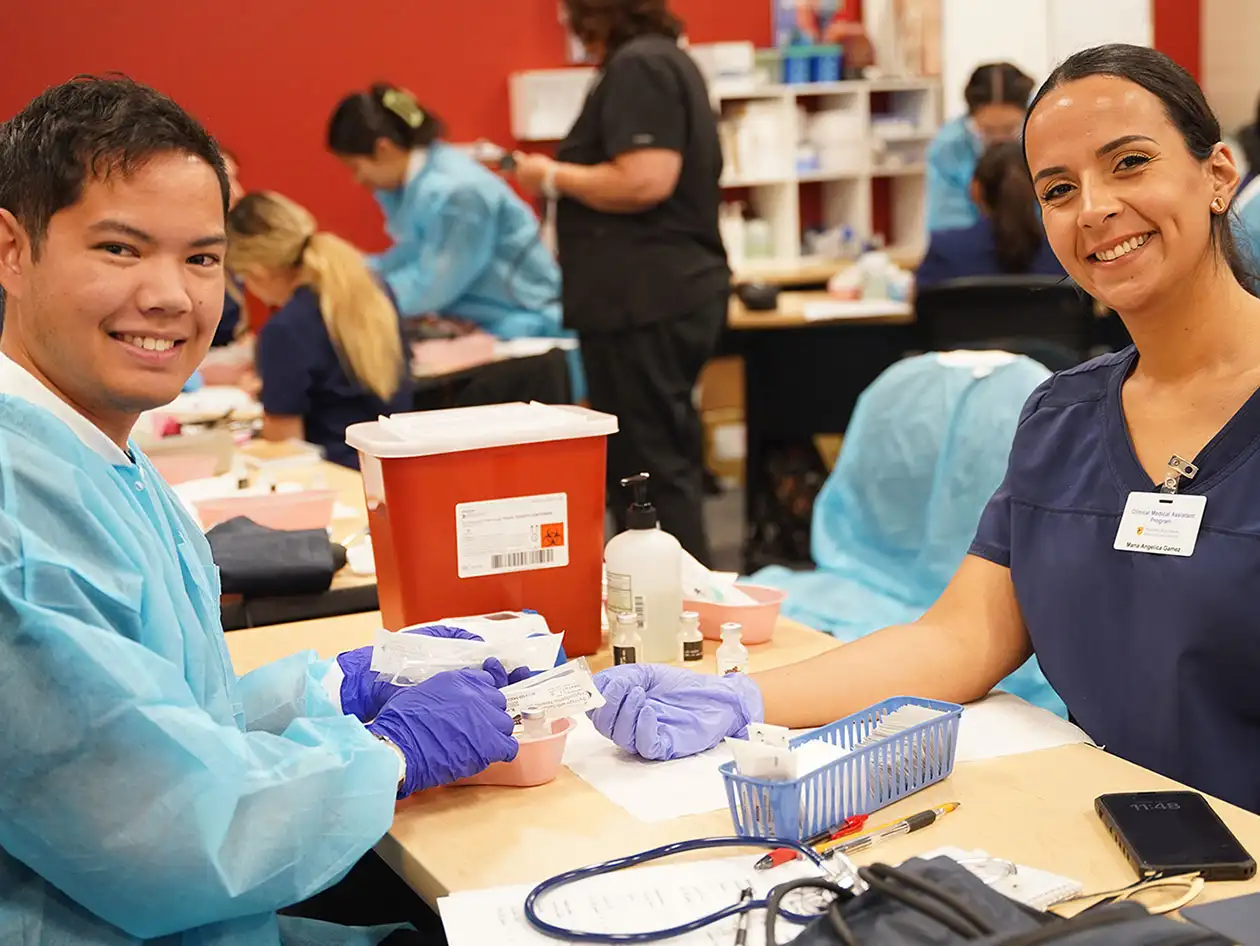 Two medical students practicing phlebotomy