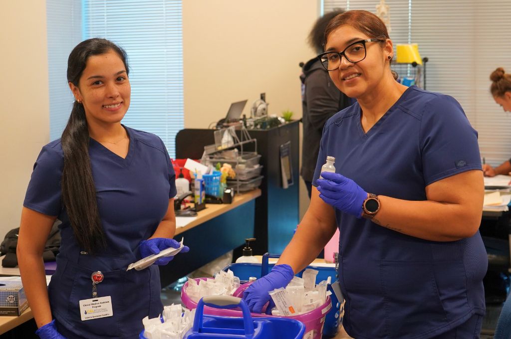 Students in Monterey County medical assistant training preparing clinical supplies during class.